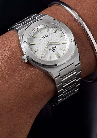 Q Timex Marbella stainless steel watch with a silver dial and integrated bracelet worn on the wrist.