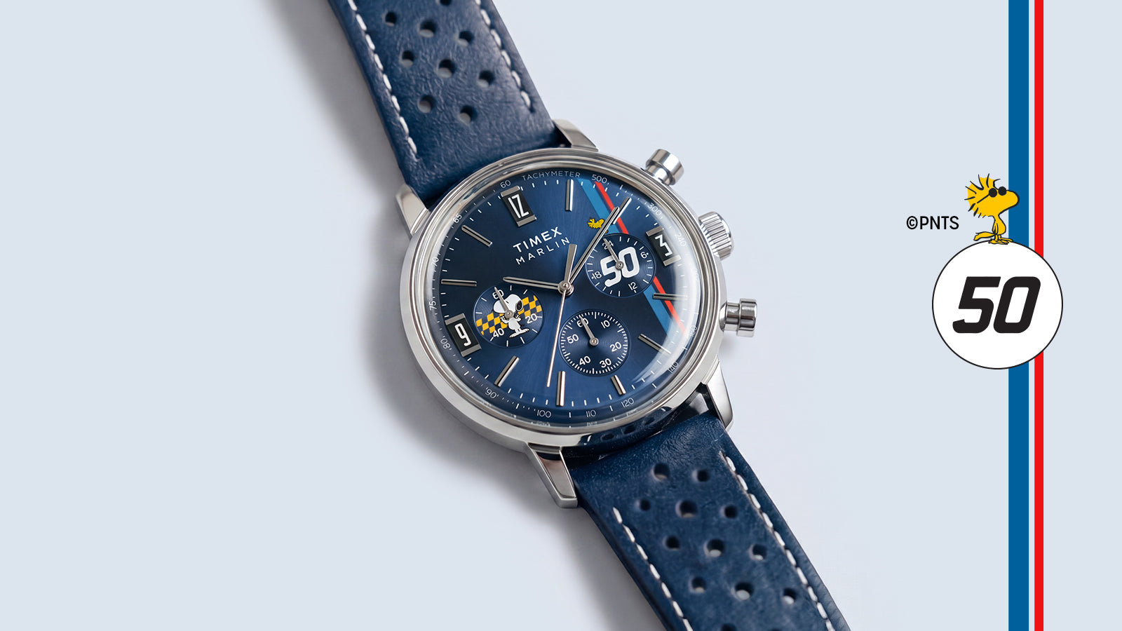 Angled view of the Peanuts® x Timex Marlin® Chronograph featuring a blue dial, perforated blue leather strap, and Snoopy-inspired racing details.