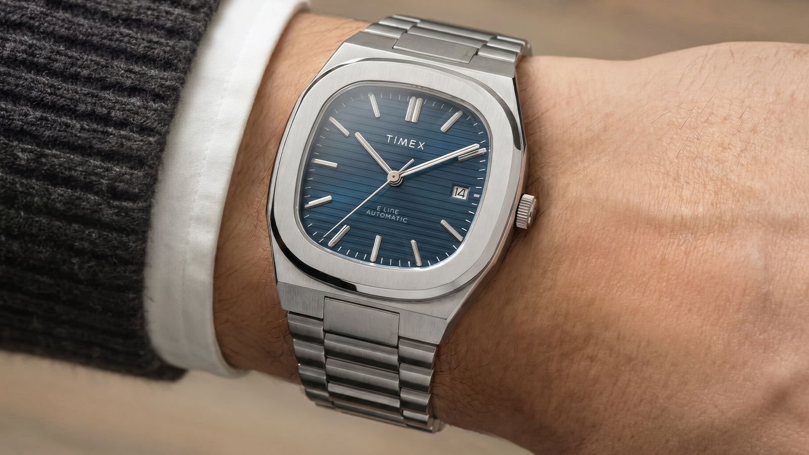 Timex® Automatic E Line 38mm stainless steel watch with a blue textured dial worn on the wrist.