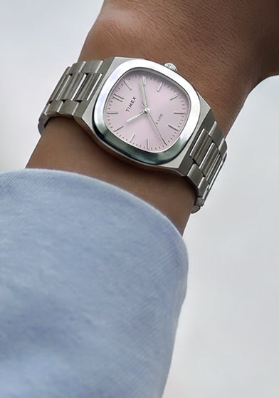 Close-up of the Timex® Quartz E Line 30mm stainless steel watch with a pink sunray dial worn on the wrist.