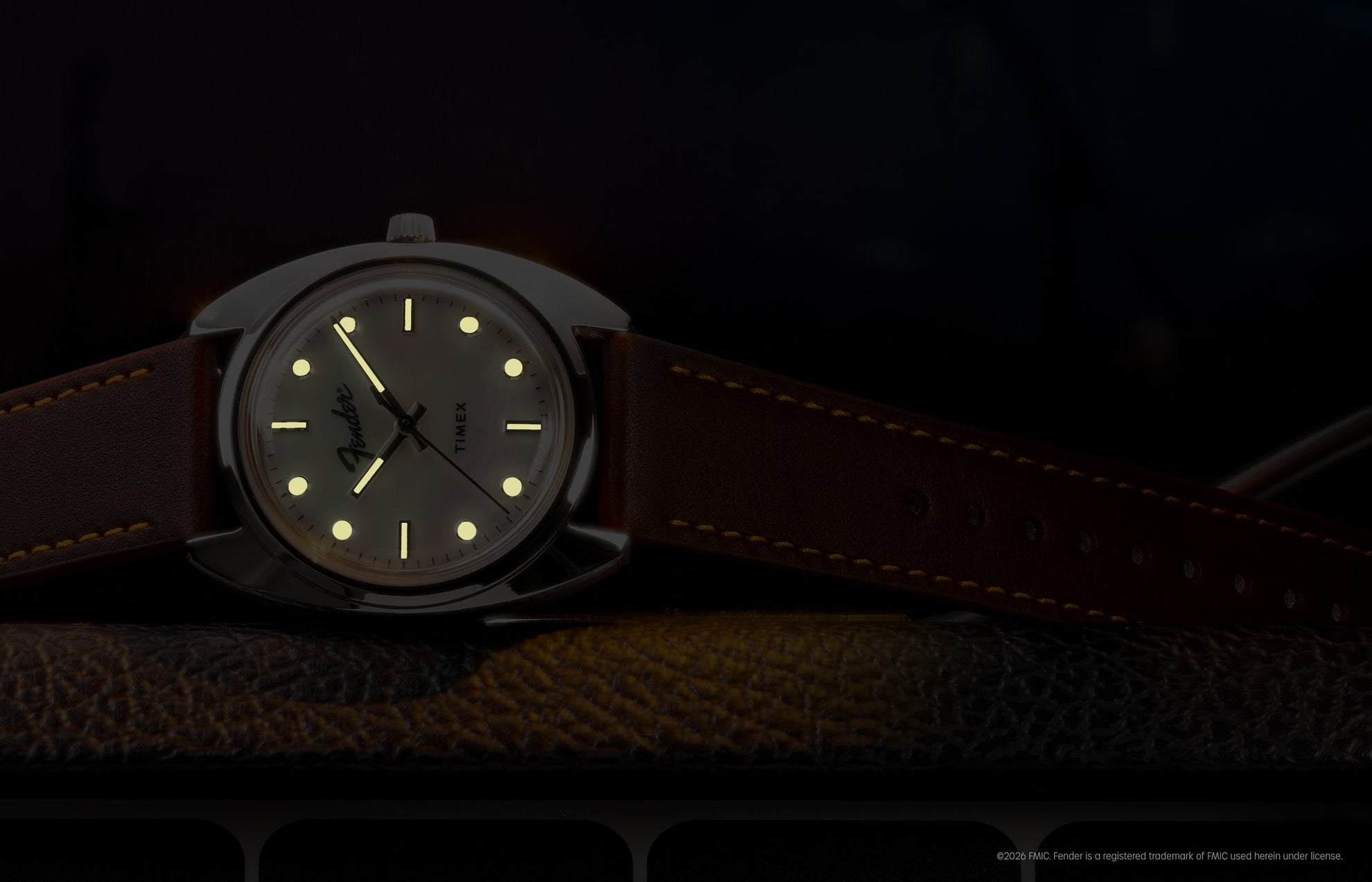 Fender x Timex watch displayed in low light with glowing hands and hour markers.