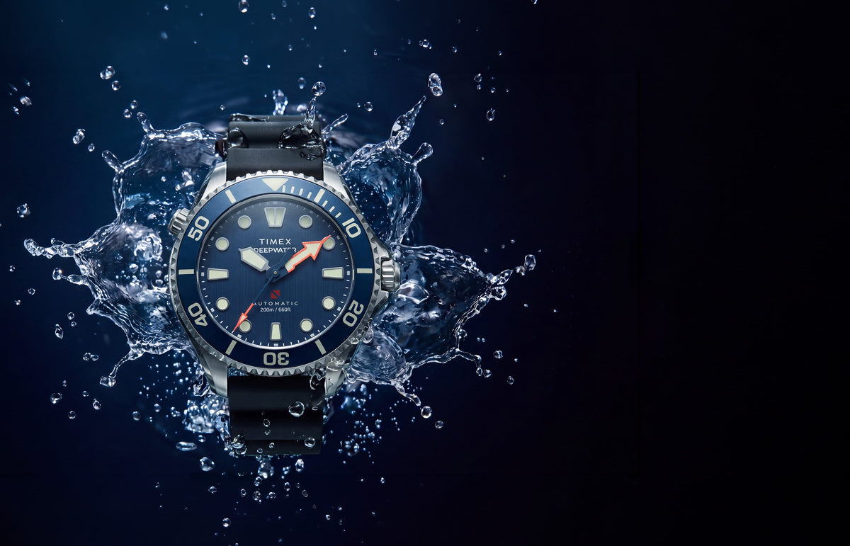 Deepwater Meridian 200 HEV Automatic with a blue dial and black rubber strap surrounded by splashing water.