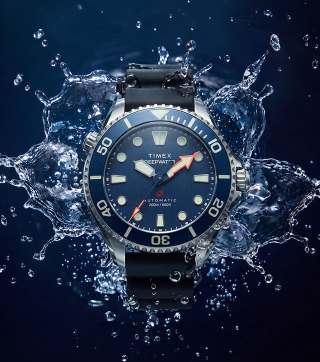 Deepwater Meridian 200 HEV Automatic with a blue dial and black rubber strap surrounded by splashing water.