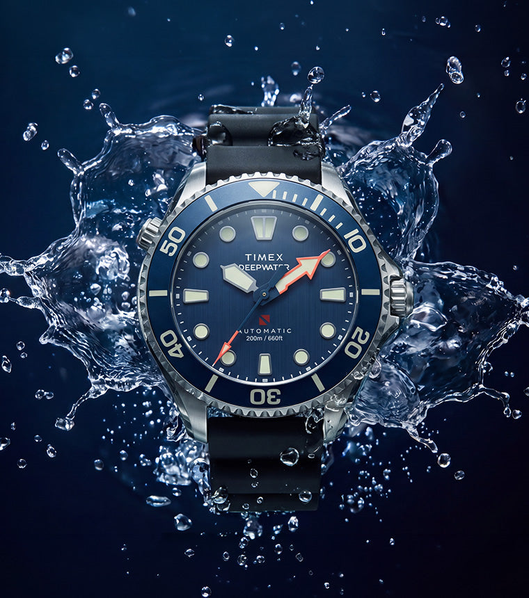 Deepwater Meridian 200 HEV Automatic with a blue dial and black rubber strap surrounded by splashing water.
