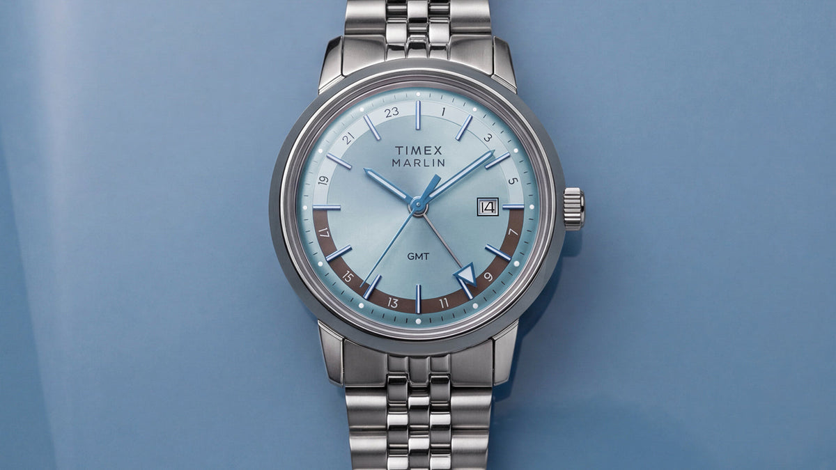 Front close-up of the Marlin® Quartz GMT featuring an icy blue dial, 24-hour scale, date window, and stainless-steel bracelet.