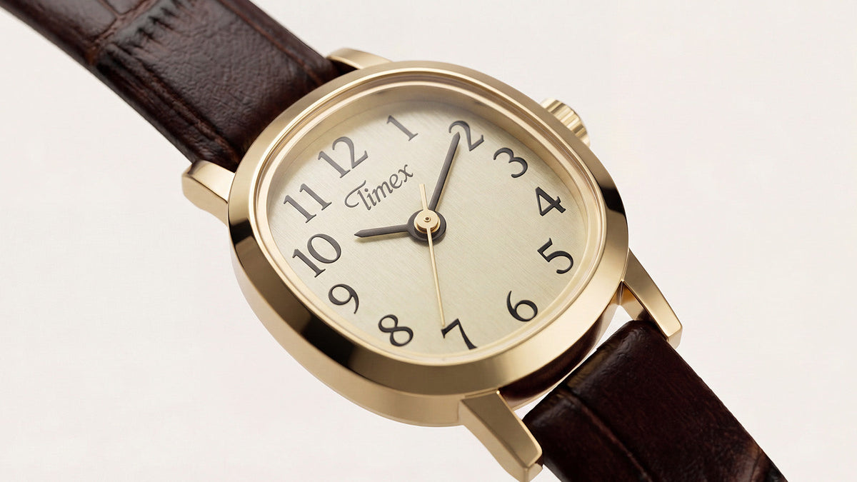 Close-up of the Cavatina® Mini featuring a gold-tone case, champagne dial, black numerals, and dark brown leather strap.