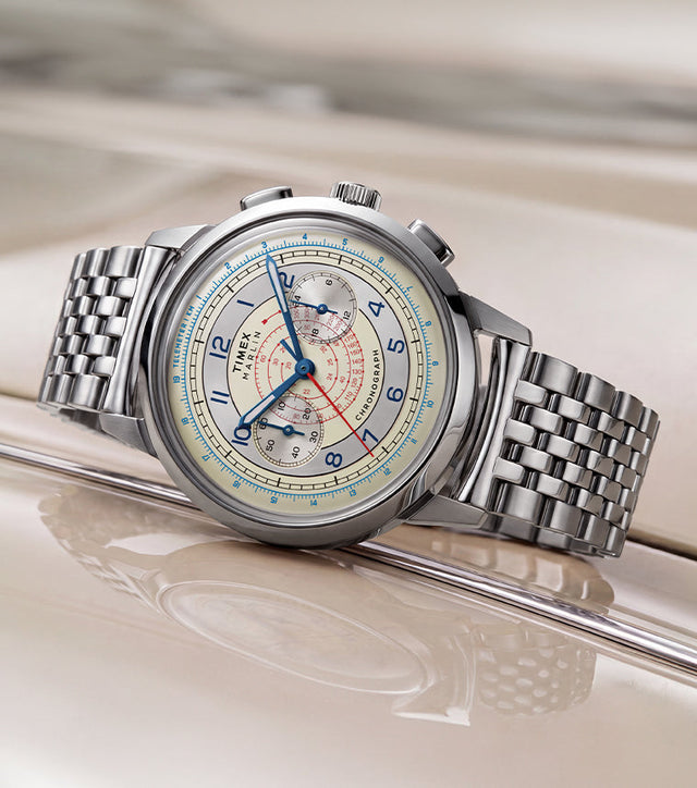 Marlin® Neo Classic Chronograph with a cream dial, blue hands, red markings, and stainless-steel bracelet resting on a cream-colored car.