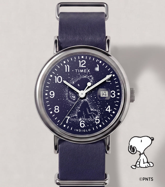 Peanuts® x Timex Weekender Astronomy watch with a navy strap, silver-tone case, Snoopy constellation dial, and date window.