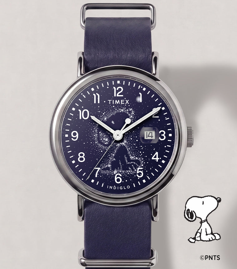 Peanuts® x Timex Weekender Astronomy watch with a navy strap, silver-tone case, Snoopy constellation dial, and date window.