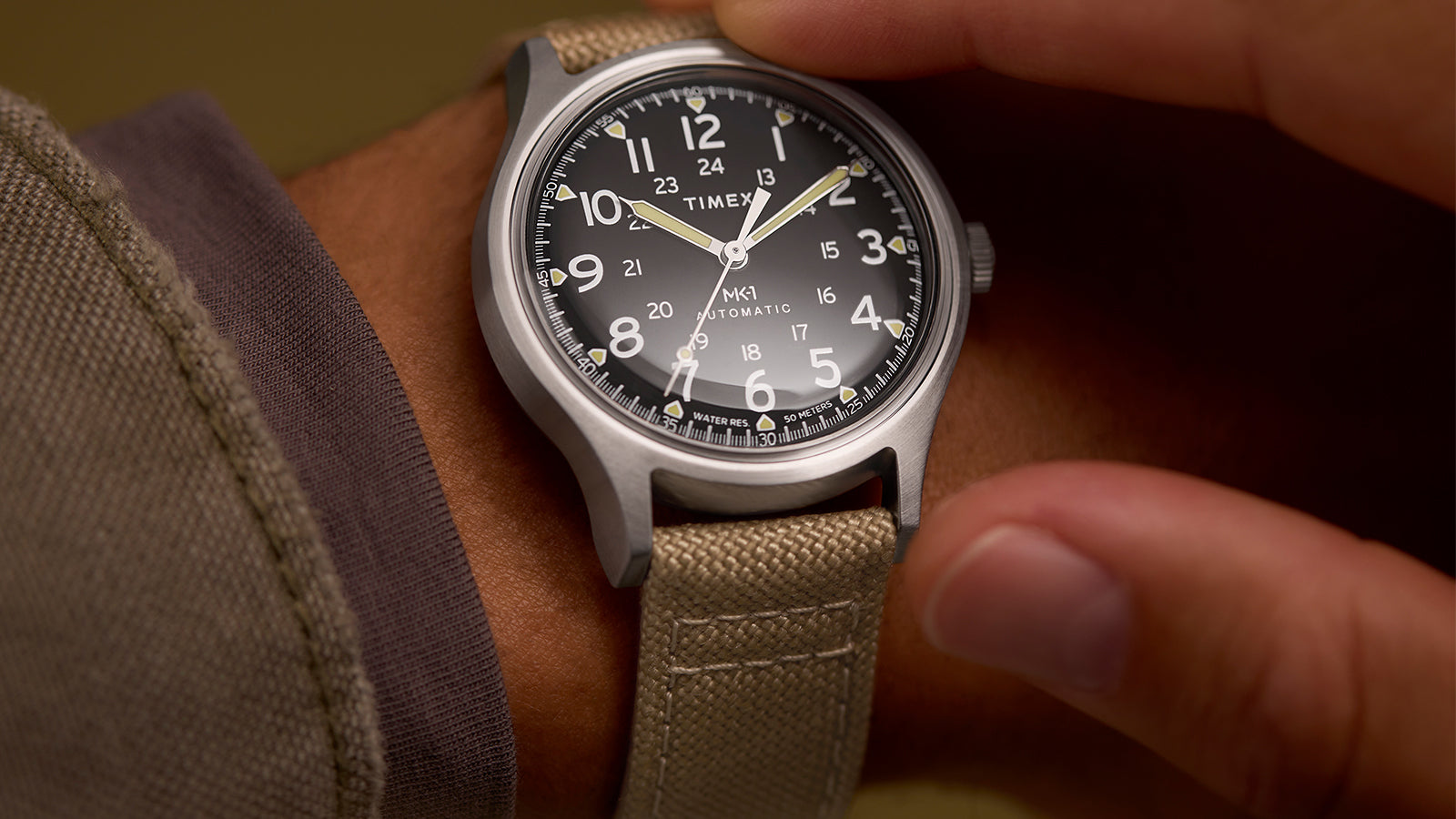 Close-up of the MK1® Automatic watch worn on the wrist while being adjusted.