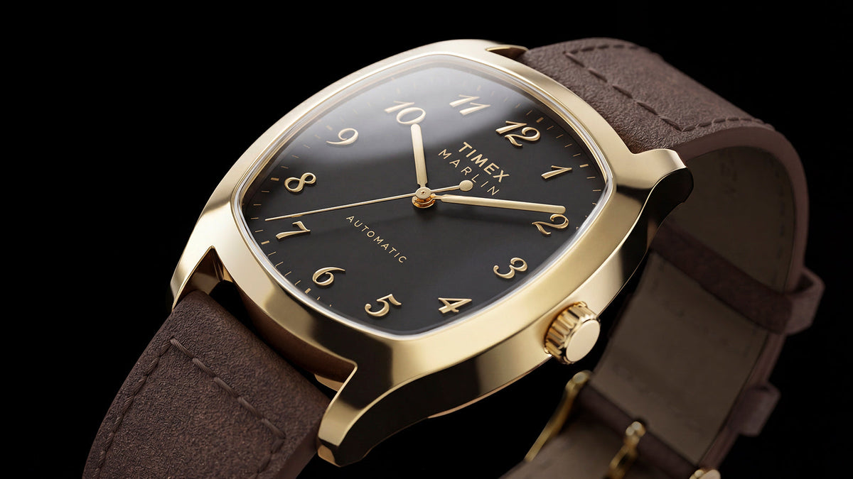 TW2Y84500 Angled close-up of the Marlin® Chatham Automatic watch with a black dial, gold-tone case and brown leather strap.