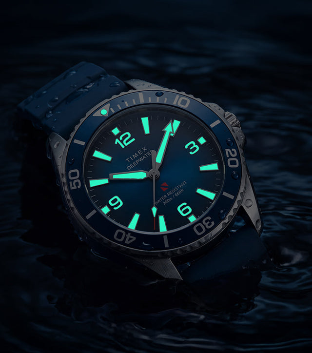 TW3A01900 Deepwater Arctic 200 watch in dark water with luminous hands and hour markers glowing aqua.