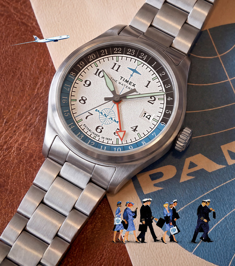 TW2Y94600 Pan Am x Timex Waterbury Automatic GMT watch displayed on vintage Pan Am materials with miniature airline crew and airplane details.