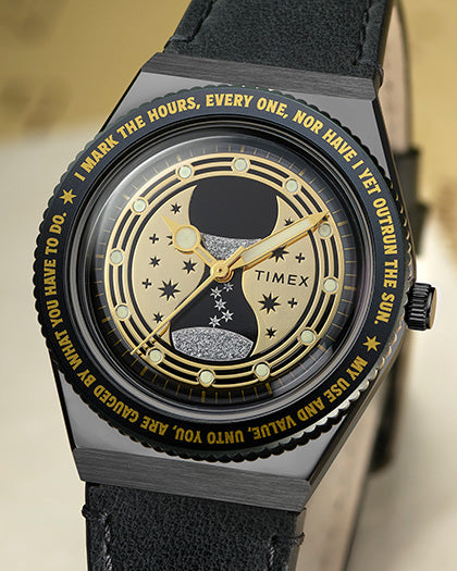 TW2Y76000 Harry Potter x Q Timex Time Turner watch, showing its black leather strap, gold-tone hands, star-patterned dial, and engraved lettering around the bezel.