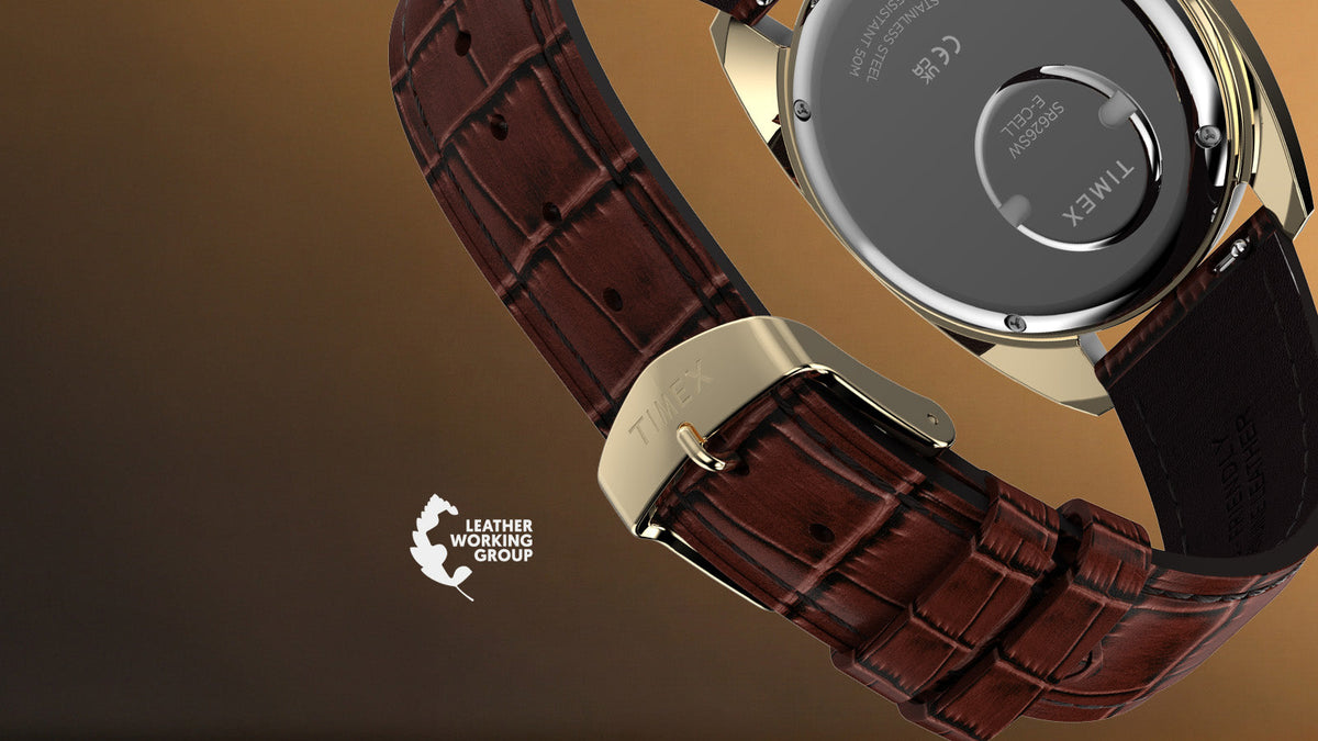 TW2Y87200 Rear view of the Timex 1978 Day Date Fumé Reissue showing its battery hatch, textured brown leather strap, and gold-tone buckle beside the Leather Working Group logo.