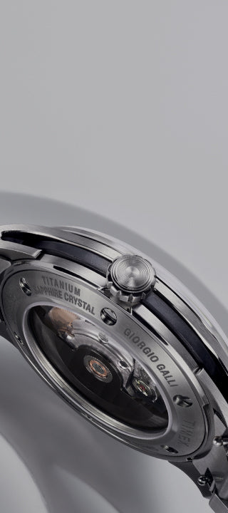 A close-up shot of the Giorgio Galli S2Ti watch, featuring a sleek titanium case and a minimalist silver dial. The timepiece has a brushed stainless steel bracelet and subtle engraved details, reflecting a modern yet timeless design. The polished hands and indices enhance the refined aesthetic, while the Swiss-made automatic movement ensures precision.