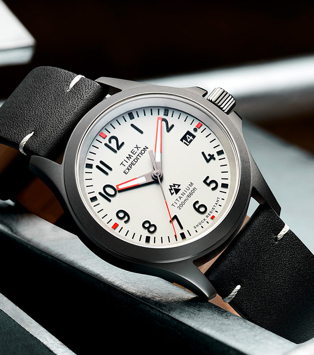 Expedition Titanium QA (38mm) Light Gray Dial and Black Leather laid beautifully in a steel with some steel chain in the side
