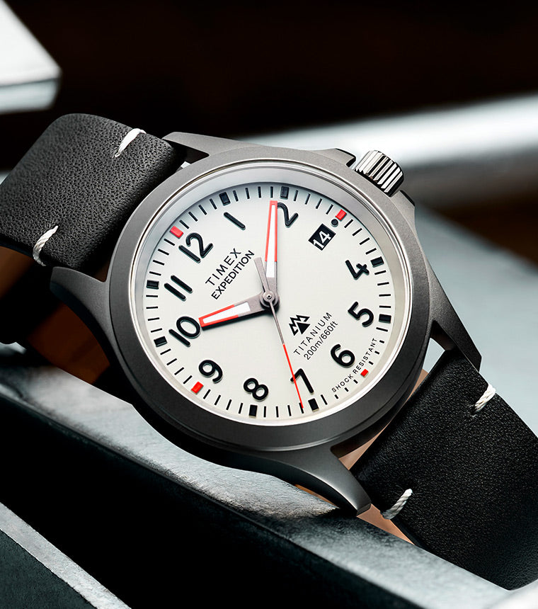 Expedition Titanium QA (38mm) Light Gray Dial and Black Leather laid beautifully in a steel with some steel chain in the side
