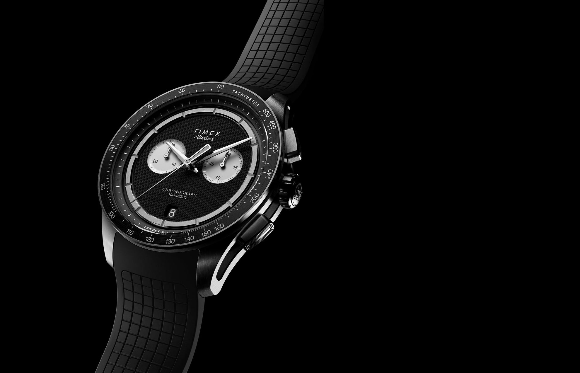 Timex Atelier Chronograph Quartz M1a 40mm Swiss Made watch with black dial and NBR synthetic rubber strap angled on dark background