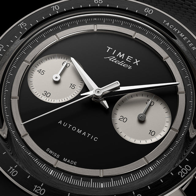 Close-up of the Timex Atelier Chronograph Automatic M1a Ti black dial featuring contrasting silver-tone sub-dials, applied markers, and polished chronograph hands.