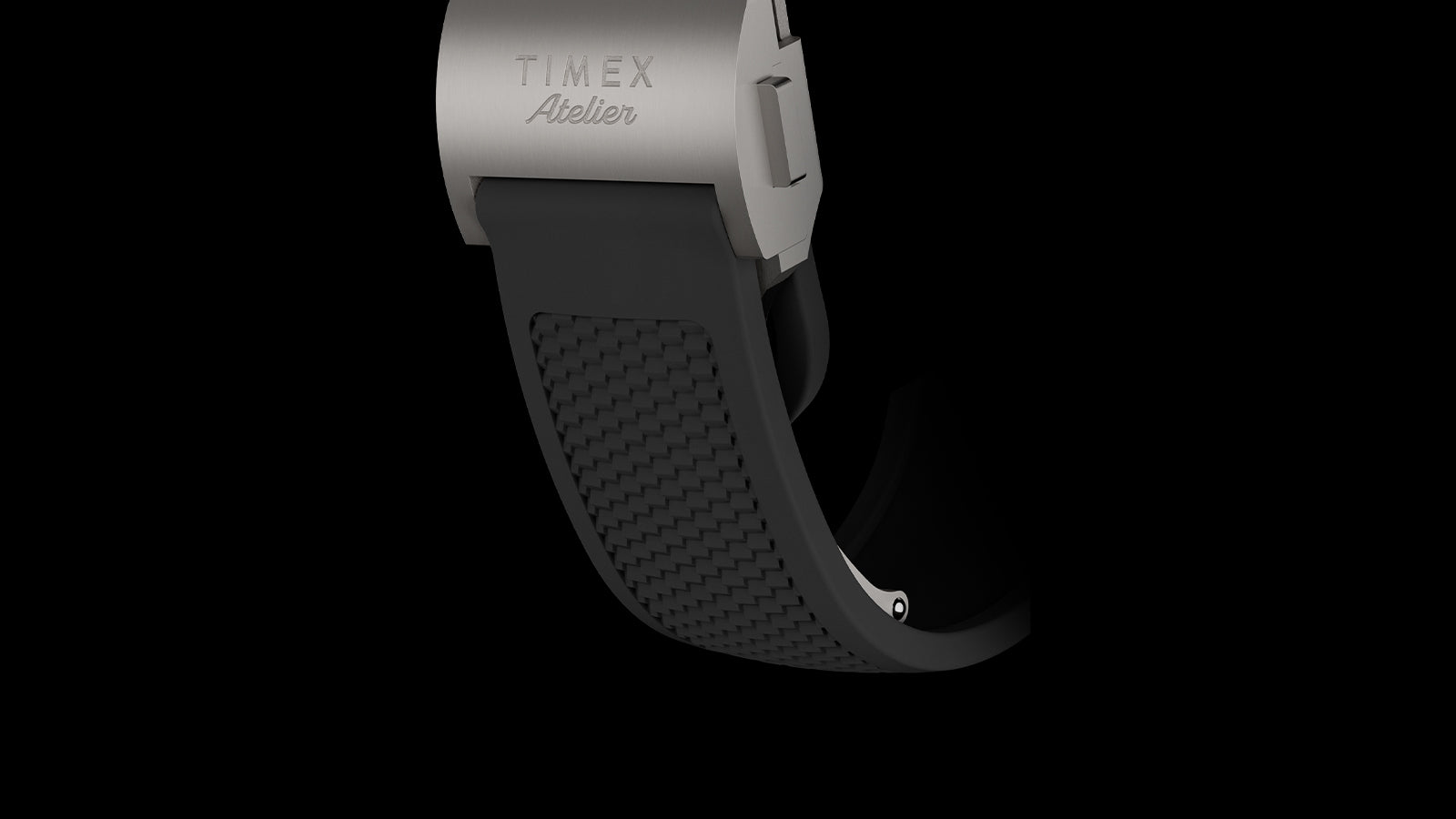 Close-up of Timex Atelier Chronograph Automatic Ti M1a rubber strap with textured pattern and titanium clasp engraved with Timex Atelier logo