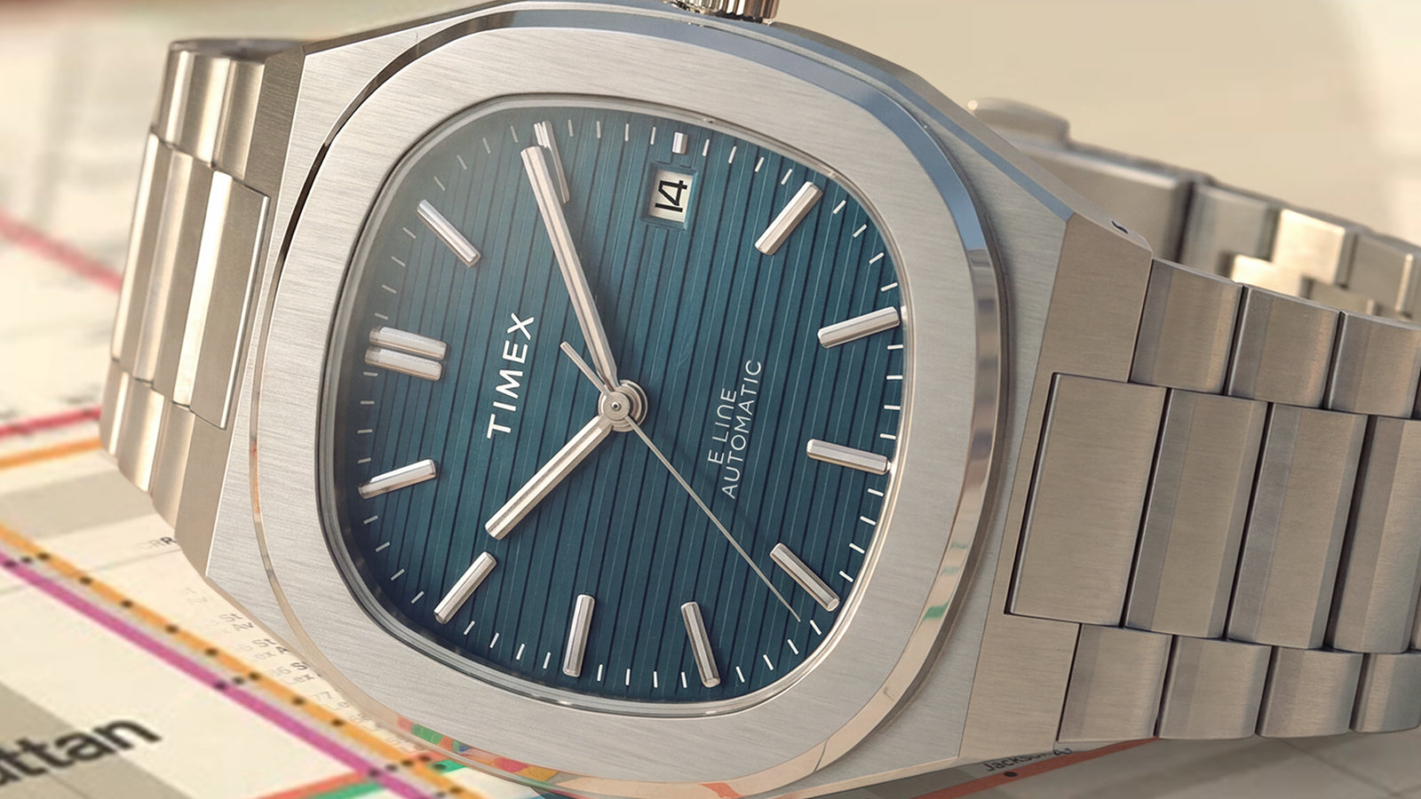 Close-up of the Timex Automatic E Line 38mm, highlighting its blue textured dial, stainless-steel case, and bracelet.
