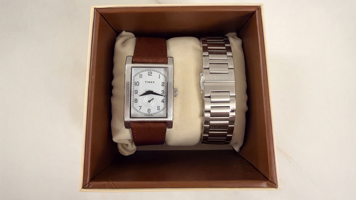 TWG069000 WM Brown x Timex rectangular watch with a silver-tone bracelet and an additional brown leather strap in an open presentation box.