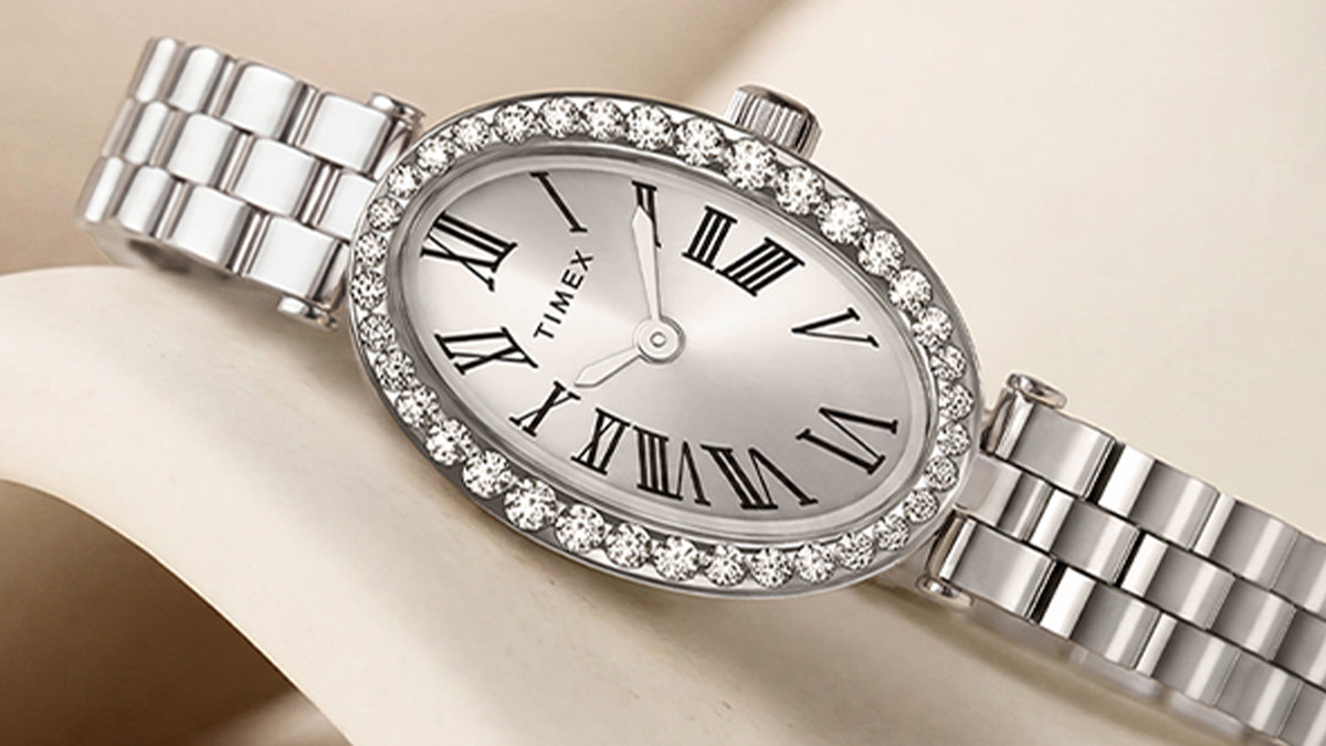 TW2Y90000 Close-up of the Timex Cavatina® Crystals watch’s silver-tone oval dial, black Roman numerals, silver-tone hands, and crystal-lined bezel.