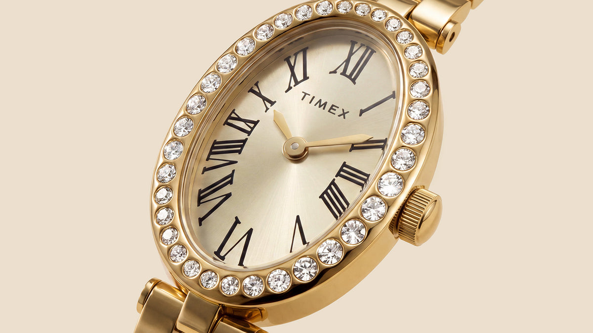 TW2Y90100 Close-up of the Timex Cavatina® Crystals watch’s champagne dial, black Roman numerals, gold-tone hands, and crystal-lined bezel.