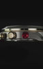 Waterbury Heritage Chronograph with a black dial, gold-tone accents, luminous hands and a red perforated leather strap against a black background.