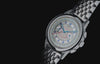 Marlin® Neo Classic Chronograph rotating against a black background, transitioning from its cream multiscale dial to green luminous hands in low light.
