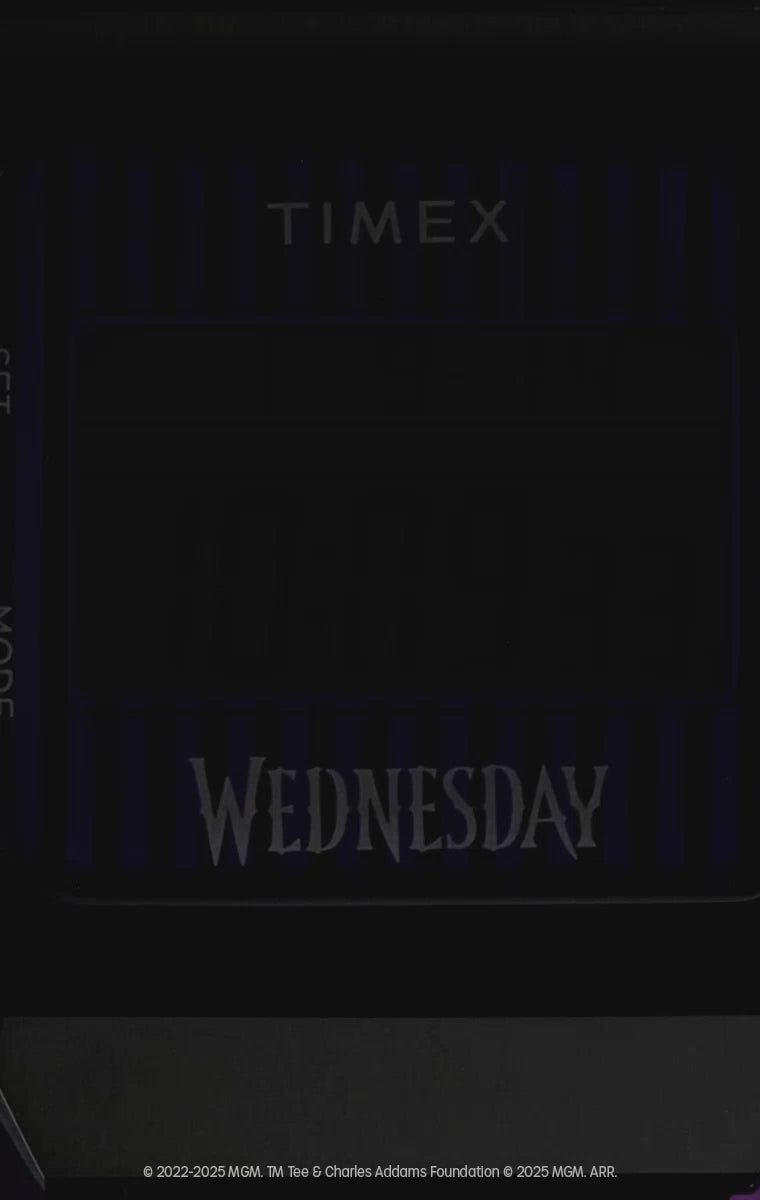 Video for the Timex x Wednesday T80 digital watch. The video features gothic-inspired visuals and a shadowy, eerie backdrop. The watch is shown from multiple angles, highlighting its black and purple striped resin strap, digital display, and bold “WEDNESDAY” branding on the dial.