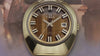Q Timex® 1972 Time Machine Reissue wristwatch featuring a polished stainless-steel case with a faceted design and hexagonal-link bracelet. The watch showcases a deep blue sunray dial with bold silver-tone hour markers accented in black, luminous hands, and a framed date window at 3 o’clock. The video captures multiple angles, including close-ups of the dial, side profile highlighting the domed crystal, and smooth bracelet links, all set against a dark blue gradient background.