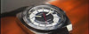 Promotional video for the Q Timex 1975 Enigma Reissue watch featuring cinematic close-ups and dynamic rotations of the stainless steel timepiece against a cosmic backdrop. The video highlights the watch’s minimalist dark blue dial with an orange seconds marker, day-date display, and integrated bracelet.