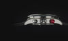 Timex Waterbury Heritage Chronograph with a stainless steel case, black leather racing strap, panda-style chronograph dial, black tachymeter bezel, and signature red chronograph pusher through rotating product views and detailed close-ups.