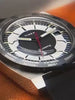 Promotional video for the Q Timex 1975 Enigma Reissue watch featuring cinematic close-ups and dynamic rotations of the stainless steel timepiece against a cosmic backdrop. The video highlights the watch’s minimalist dark blue dial with an orange seconds marker, day-date display, and integrated bracelet.
