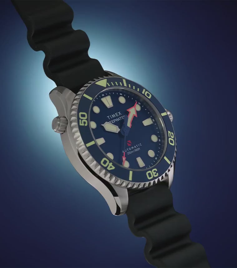 Deepwater Meridian 200 HEV Automatic watch rotating against a dark blue background, showcasing its blue dial, dive bezel, stainless-steel case, and black rubber strap.